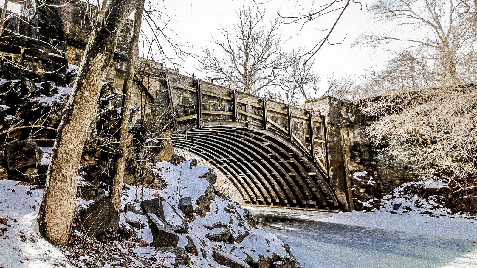 A single arch aqueduct spans a creek.