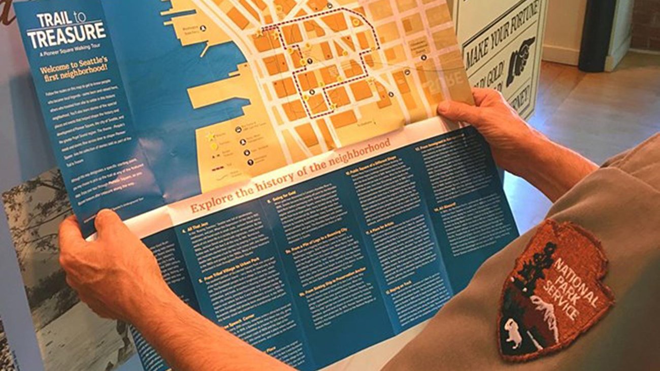 Ranger holding Trail to Treasure Walking Tour map.