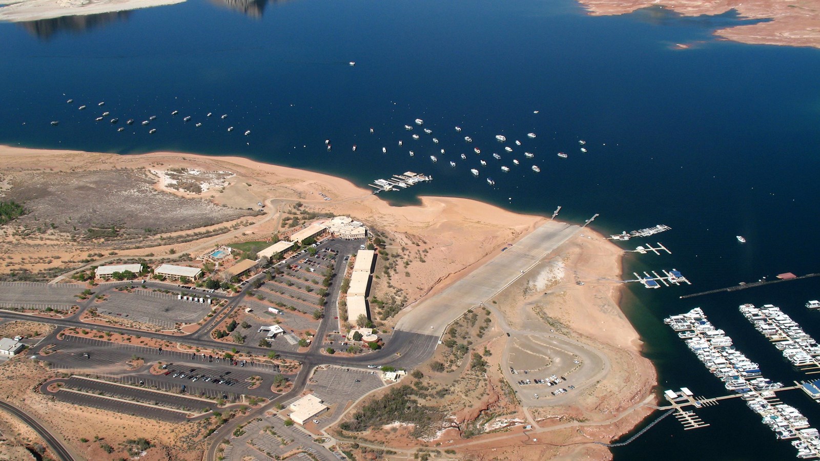 Aerial view of lake with roads, buildings, and launch ramp