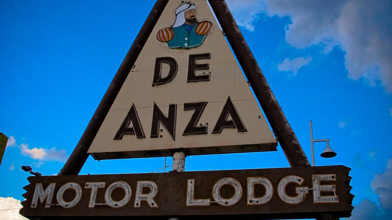 A brown and white sign that reads