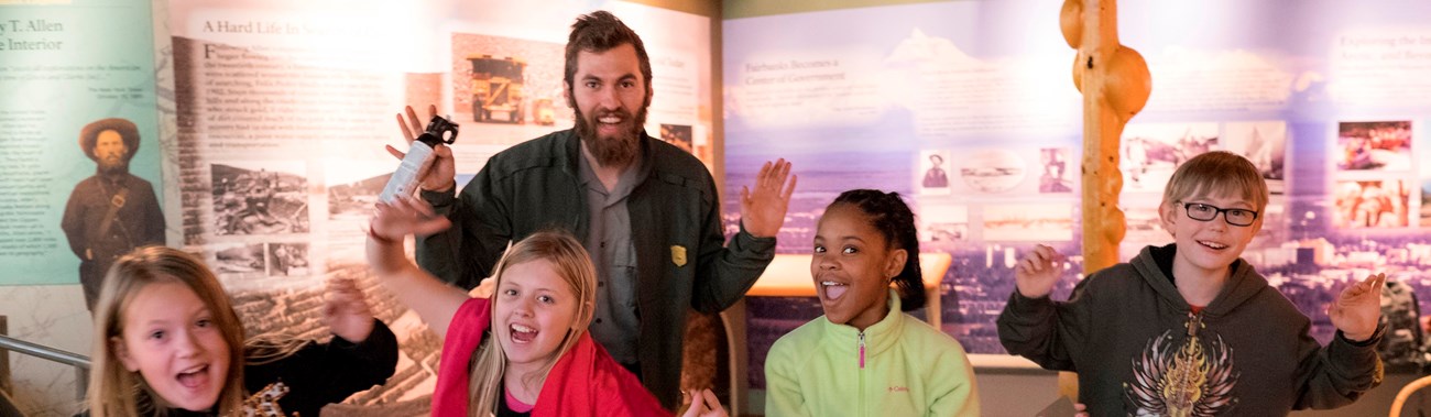 A ranger and four children pose for a picture in the visitor center