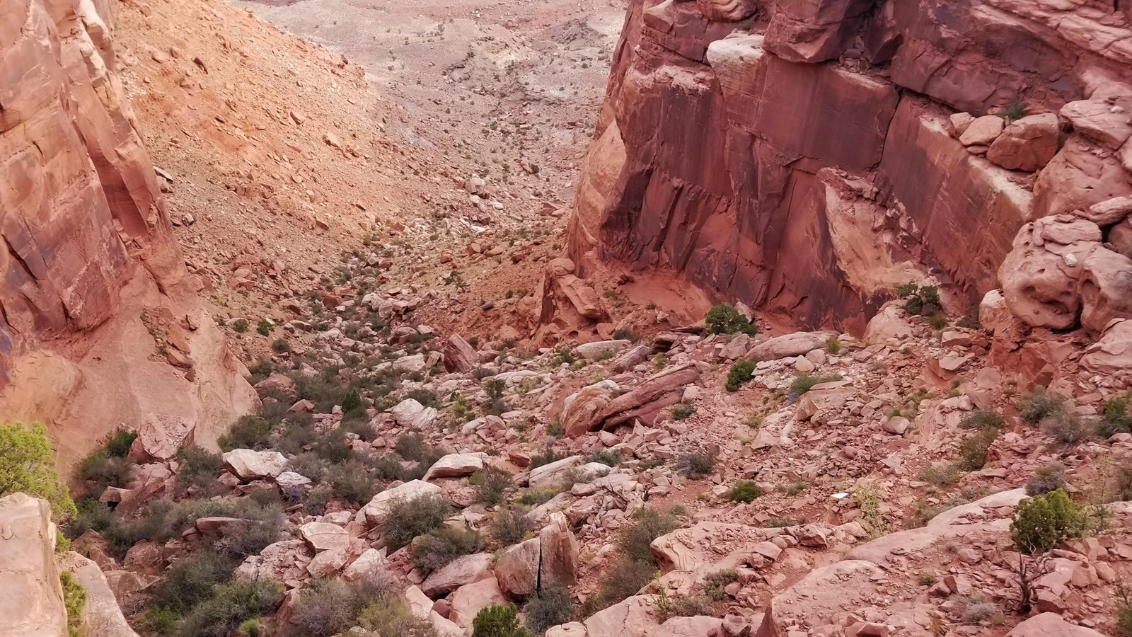 a primitive trail winds down a rocky, unmaintained wash 