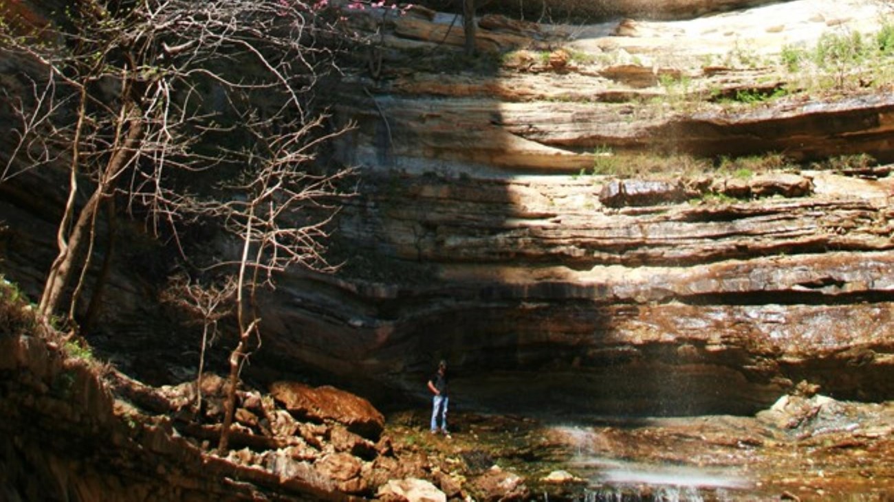 A hiker at the bottom of Hemmed-In Hollow Falls 