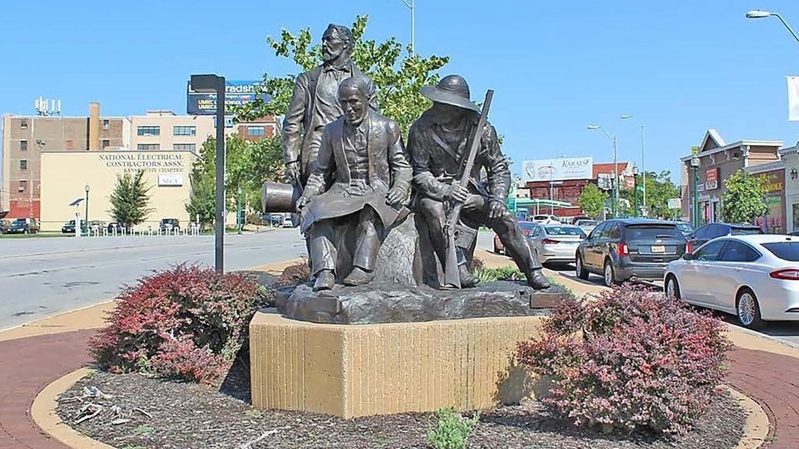 A bronze statue of early pioneers in a town center park.