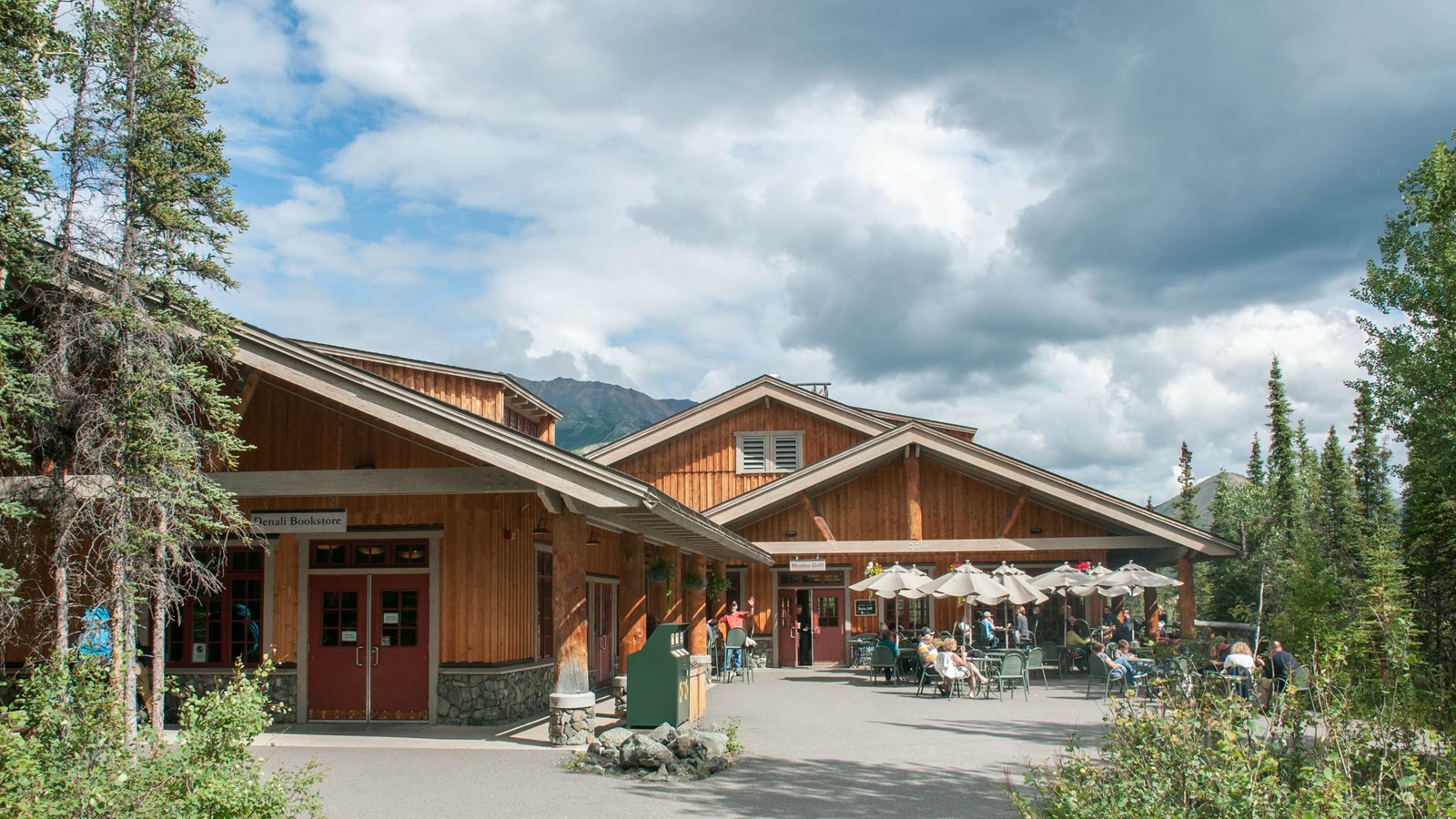 Several one-story buildings amid spruce trees