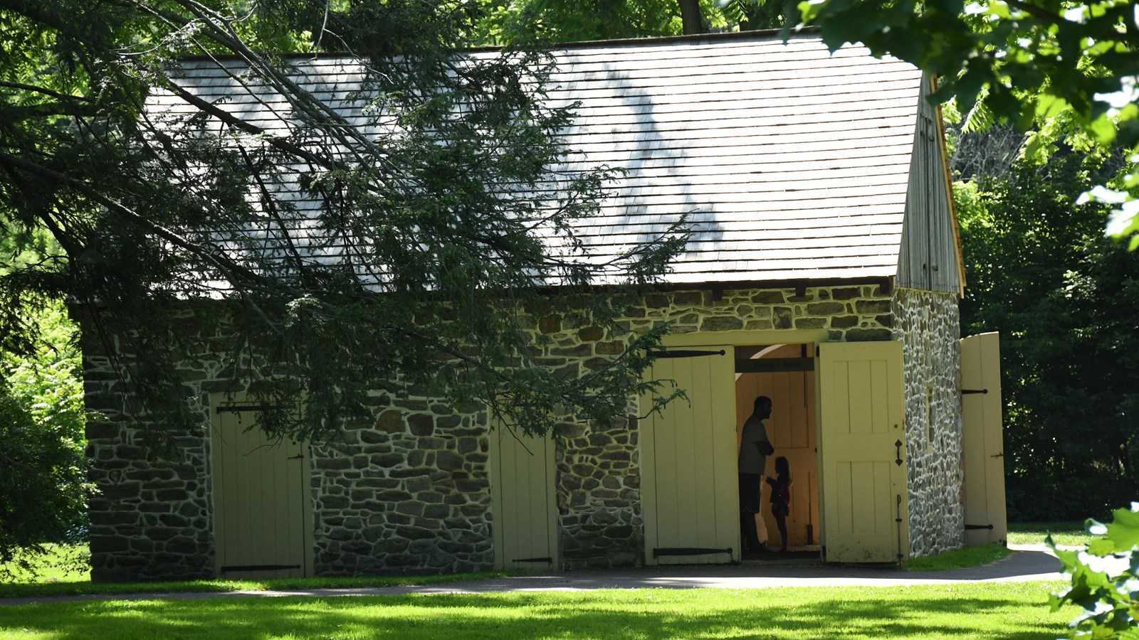 small stone building with an open door and people inside