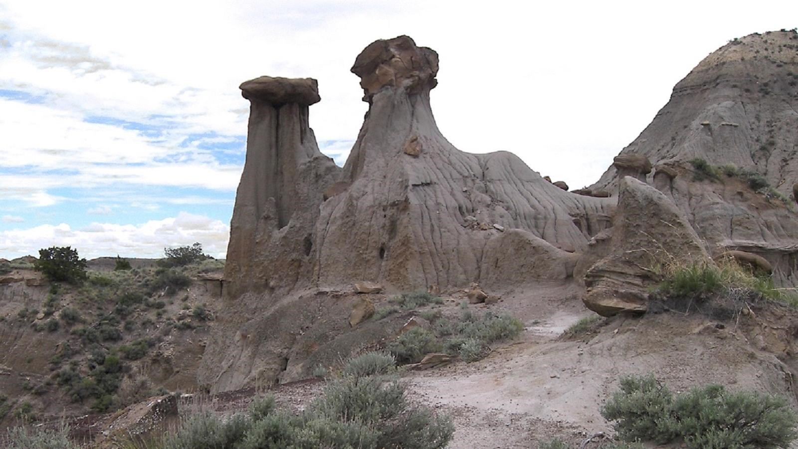 two large boulders perch atop sandstone pillars