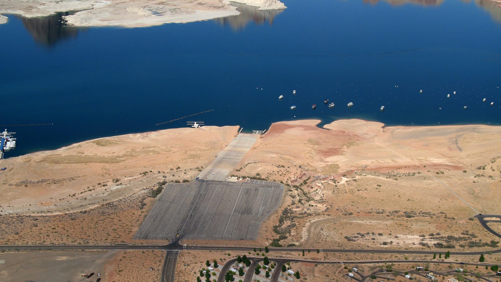 Aerial view of lake with roads, buildings, and launch ramp