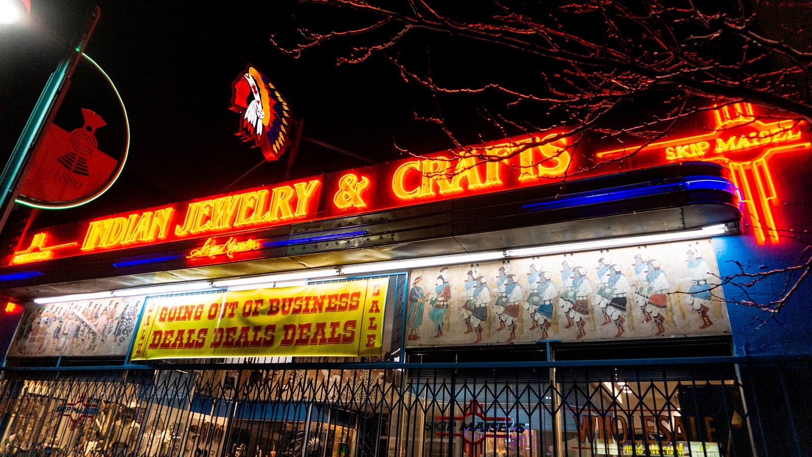 A blue building at night with red neon lights that read 