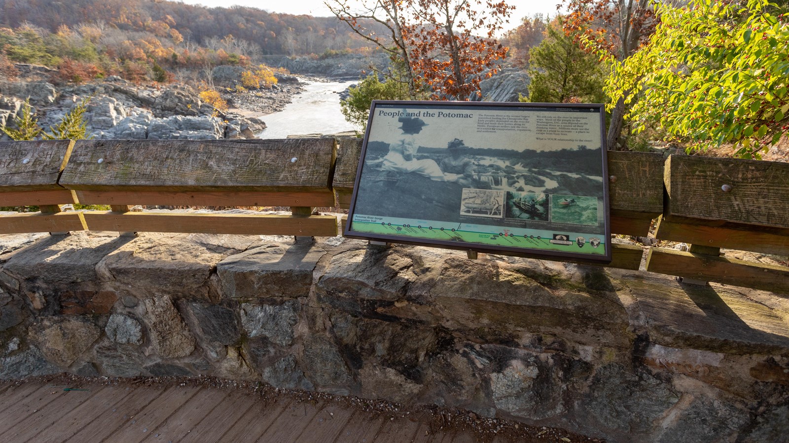 A black and white image of two women sitting on rocks overlooking the river in 1920 is displayed.