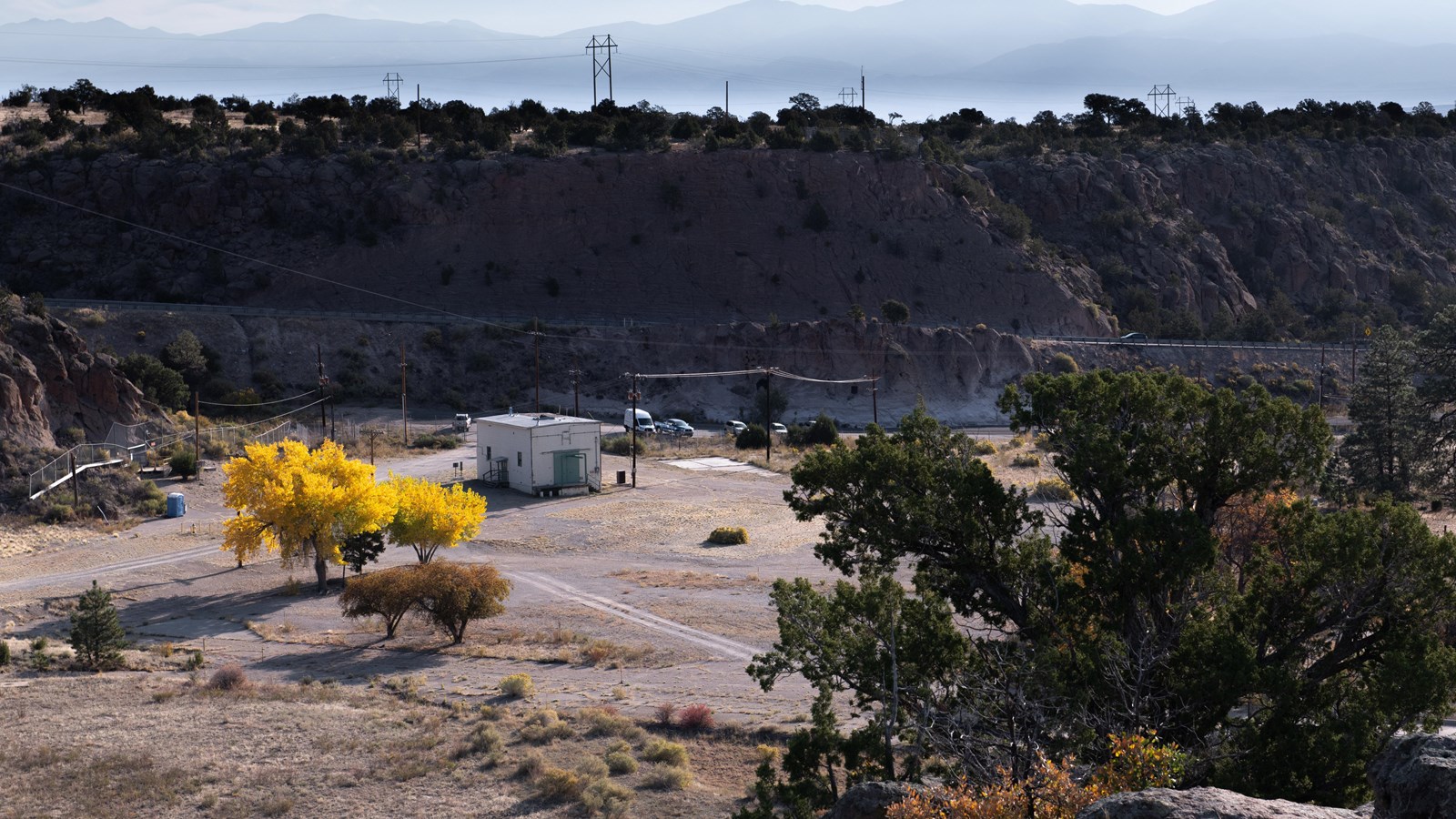 A view into a forested technical area from the top of a rocky area.