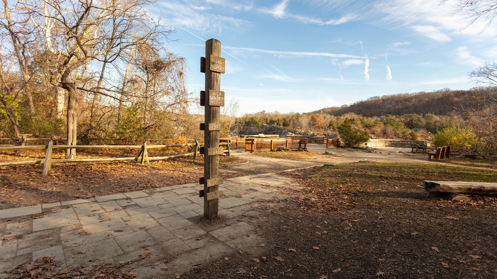 A pole acting as a flood marker has 7 dates to indicate the height of floods from different years.