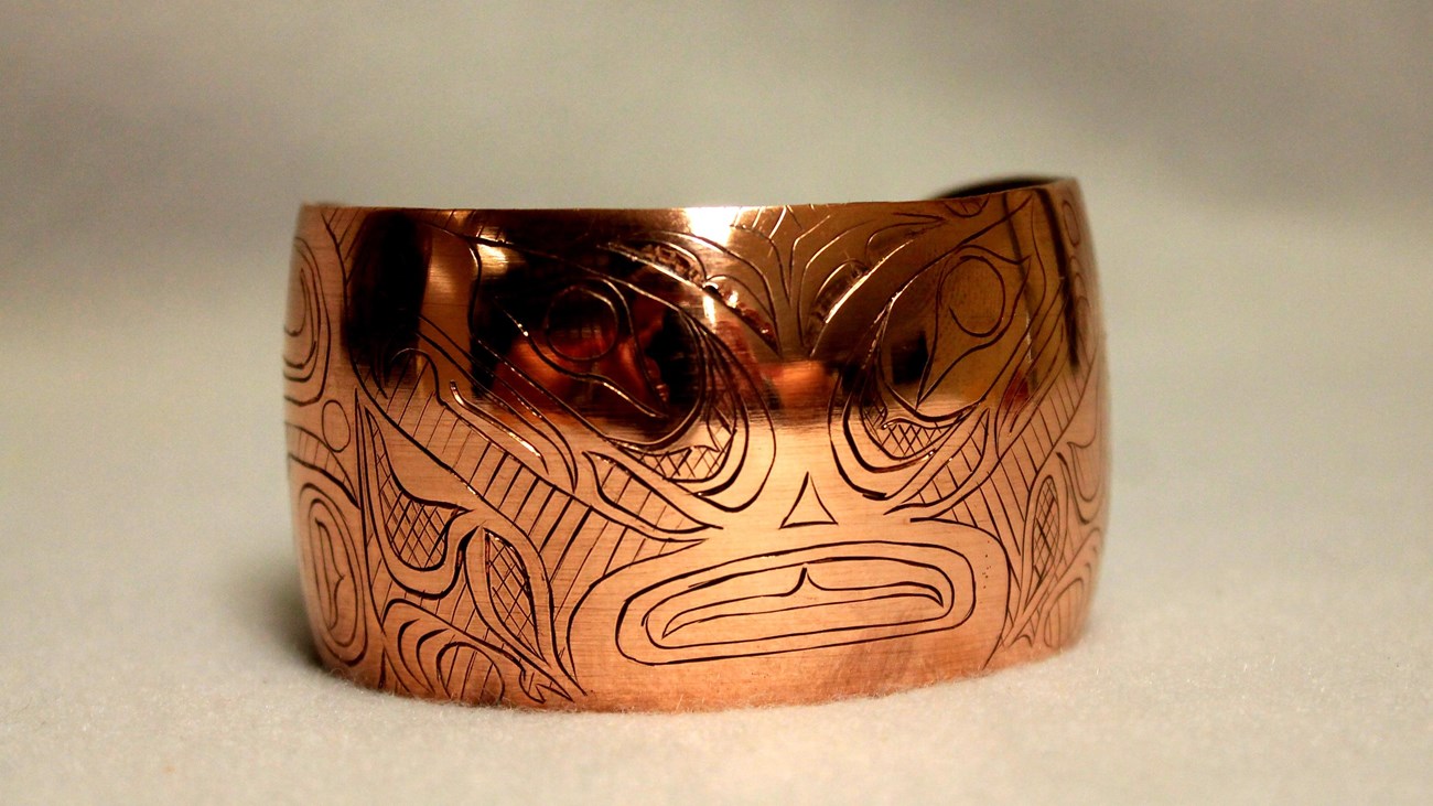 A copper bracelet with stylized engraving