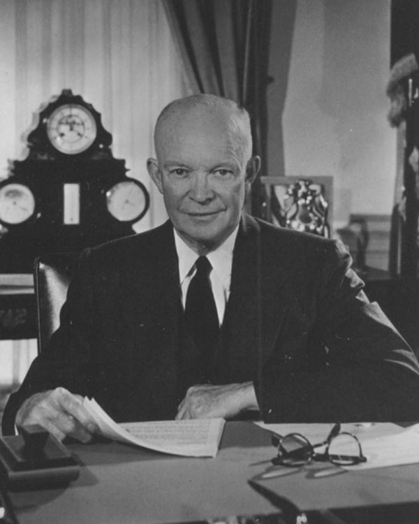 Black and white image of Dwight Eisenhower sitting at a desk
