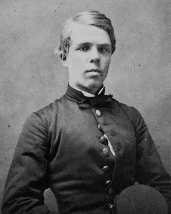 Man in uniform holding a hat.
