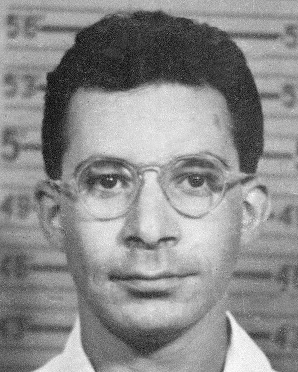 Black and white photo of a man with short dark hair and glasses.