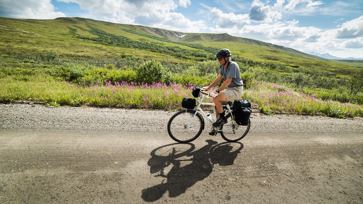 a person riding a bicycle on a dirt road