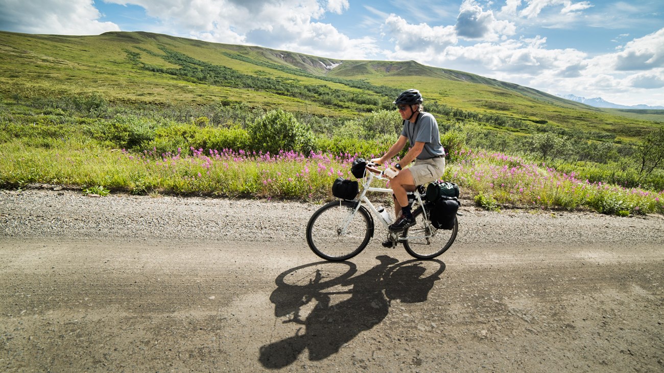 a person riding a bicycle on a dirt road