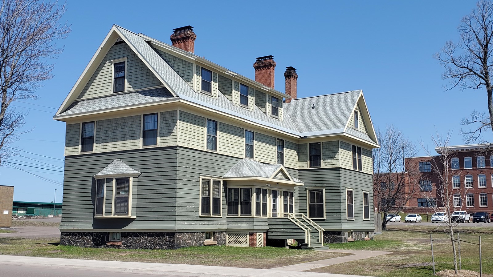 Two story house with green wooden siding.