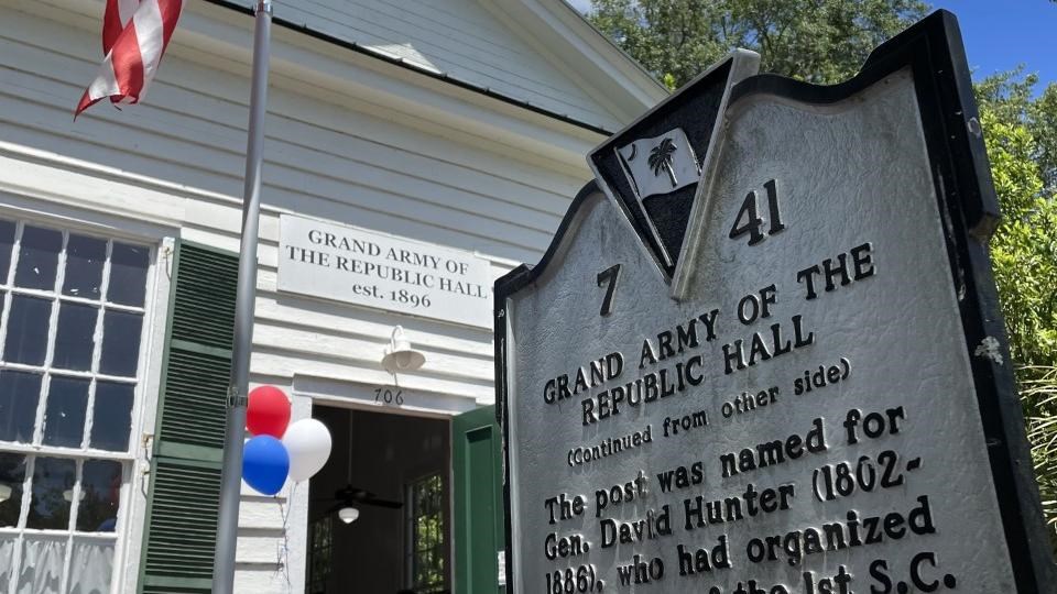 A sign in front of a white building reads 