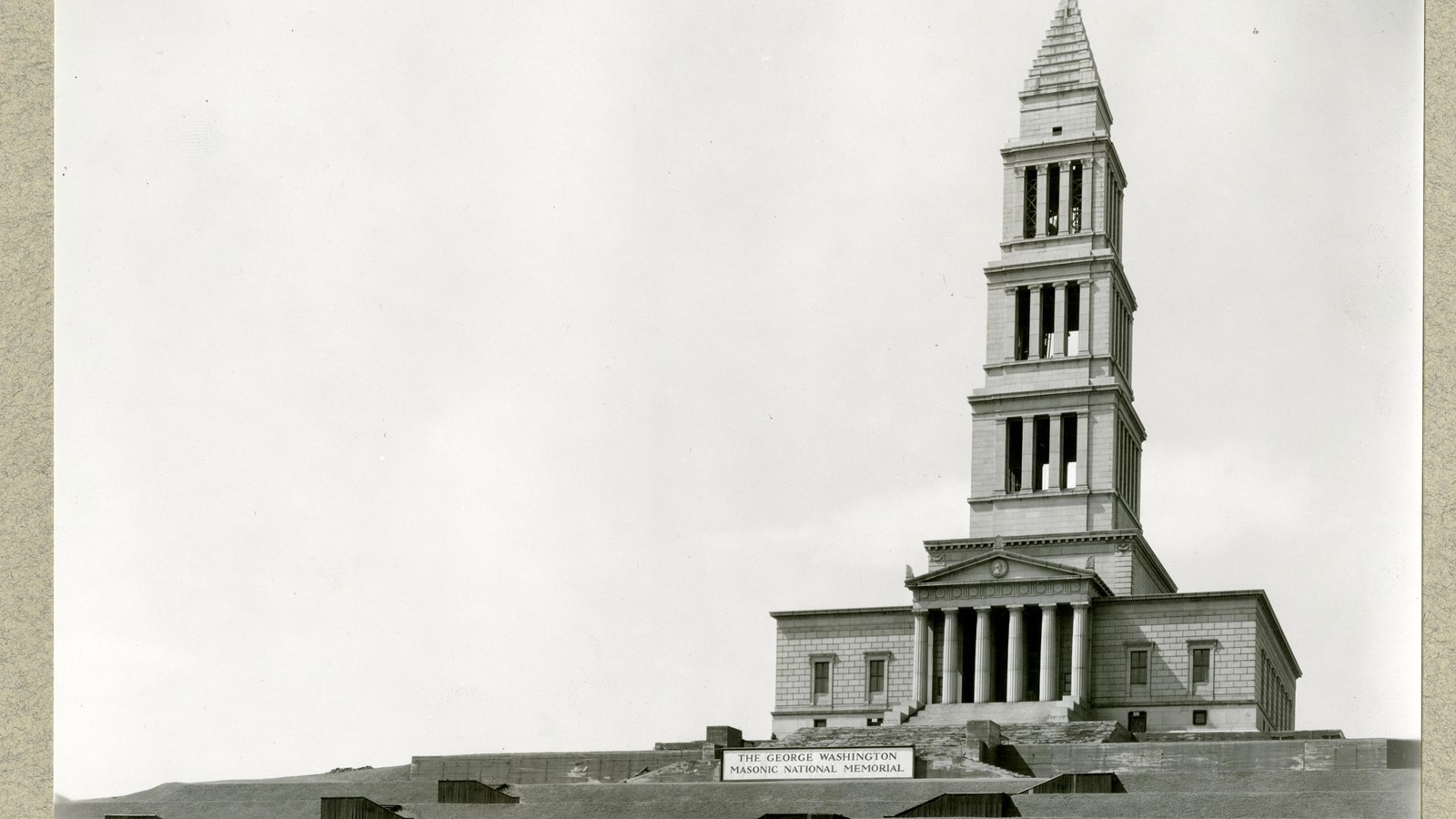 Black and white of large symmetrical tower on top of terraces hill with steps leading up 