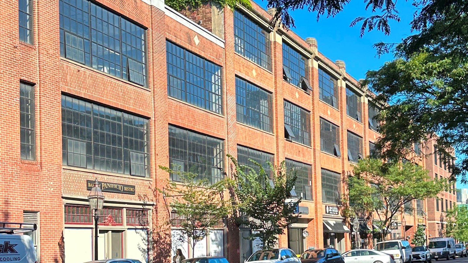 View up a street looking at a brick and glass parking garage