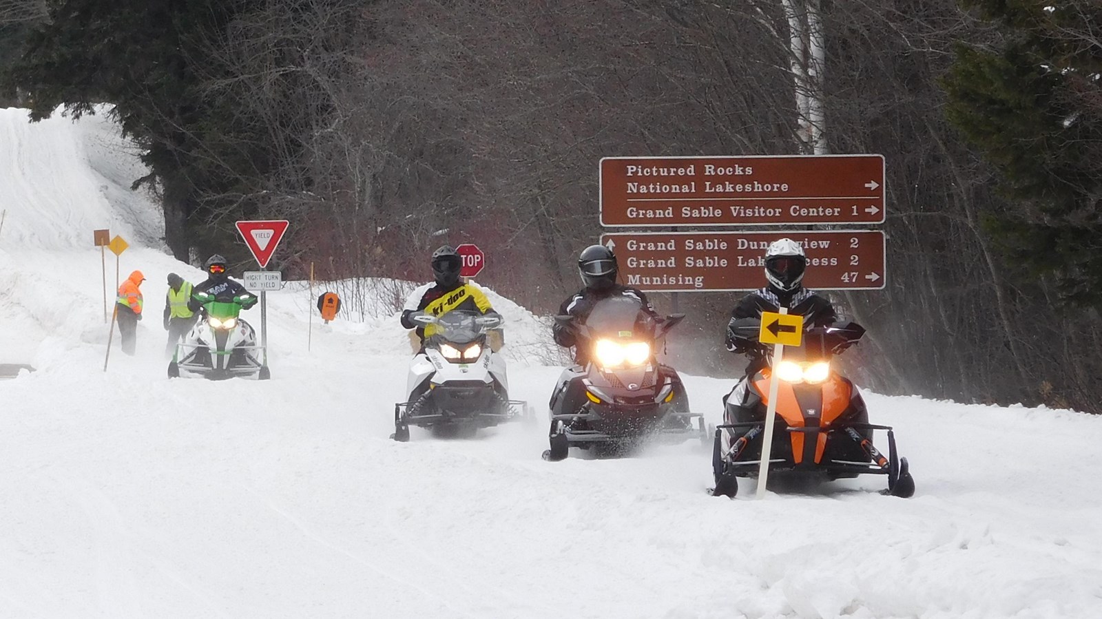 Group of snowmobilers coming down the road