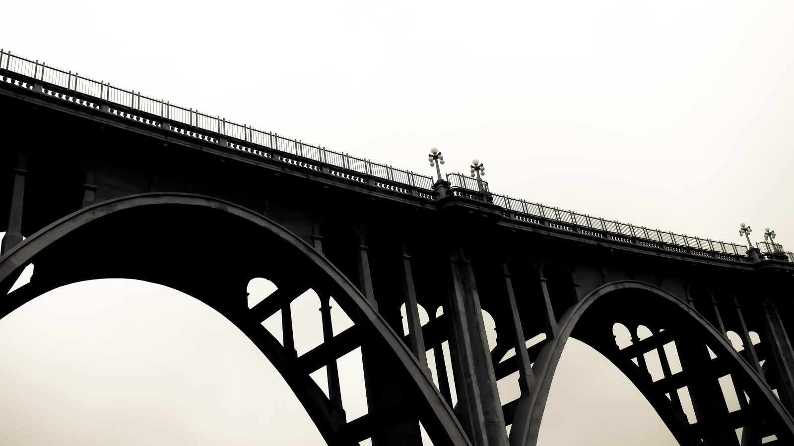 A large concrete bridge with arches and railings at the top.