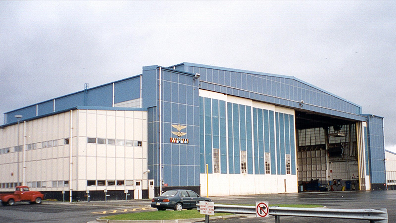 A large blue and white airplane hangar with with its door open.