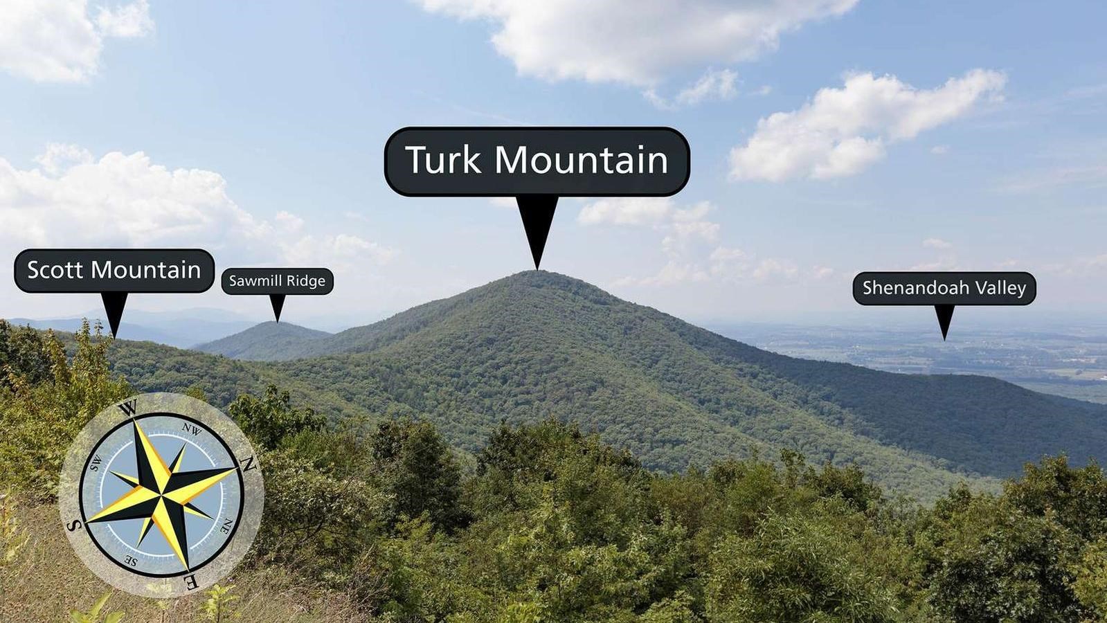 A view from a mountaintop looking toward another mountain.