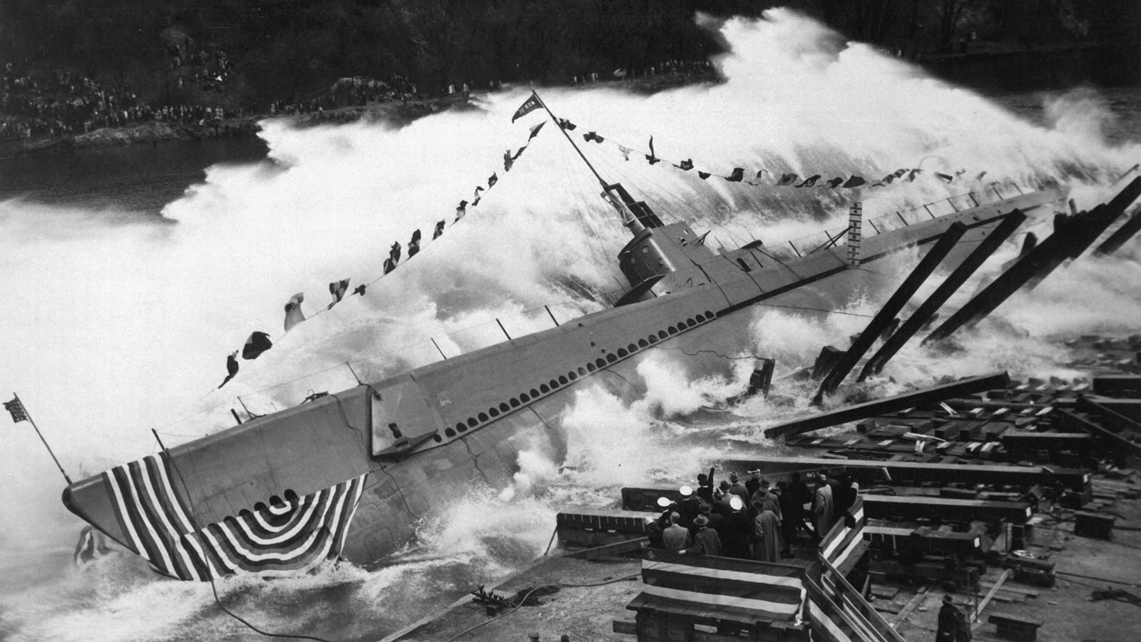 Men put the finishing touches on a docked submarine 