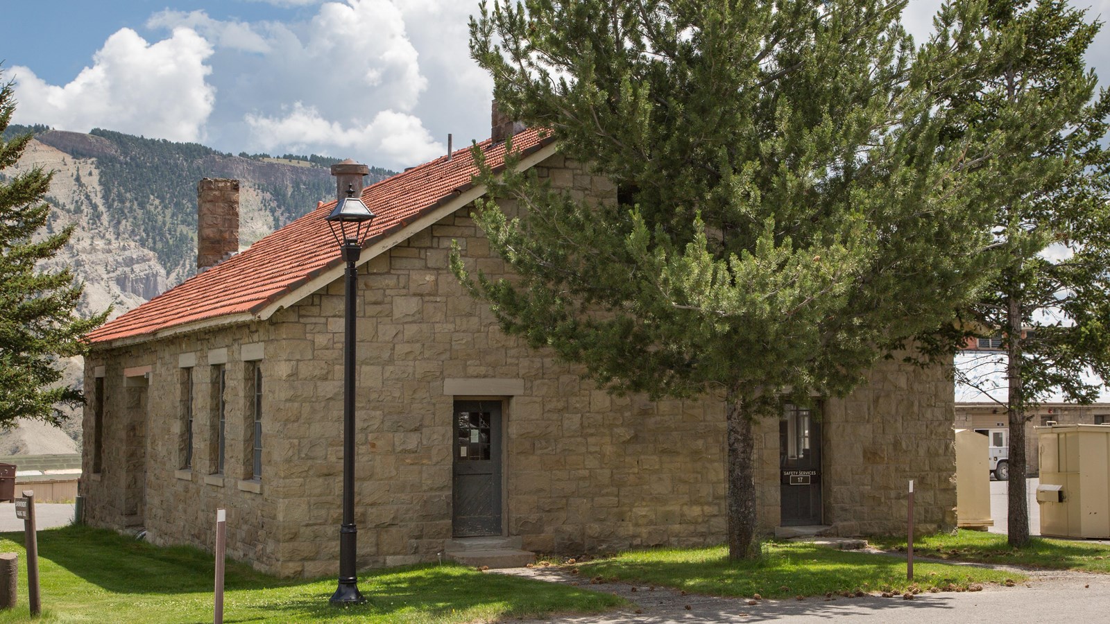 A historic building made out of stone with a red roof shingles.