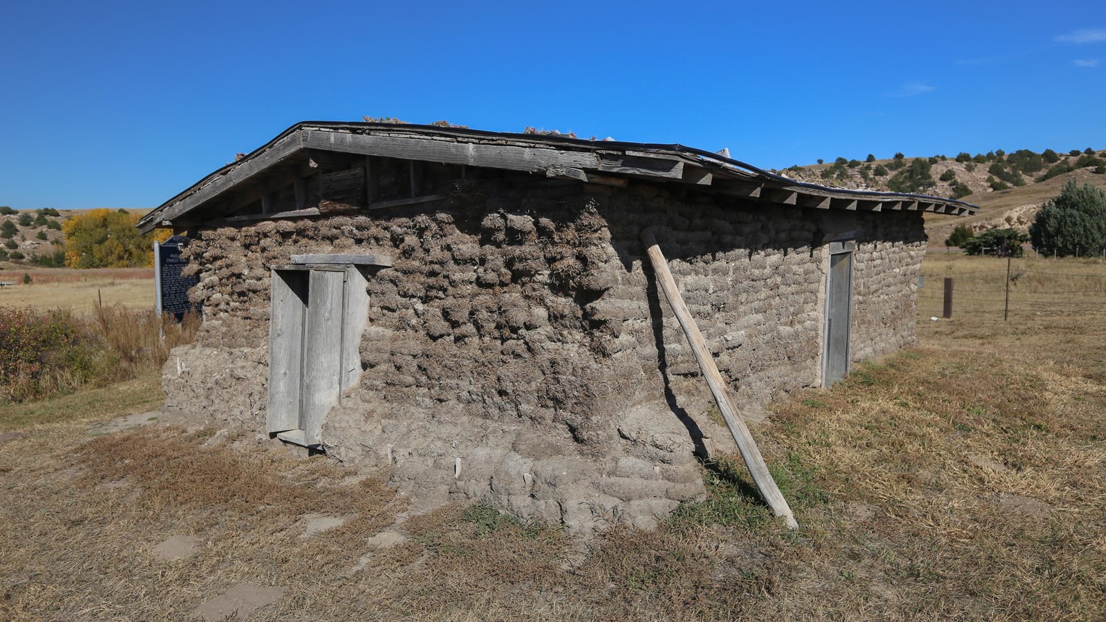 A small square house made out of dirt bricks, with one opening on each side and a roof.