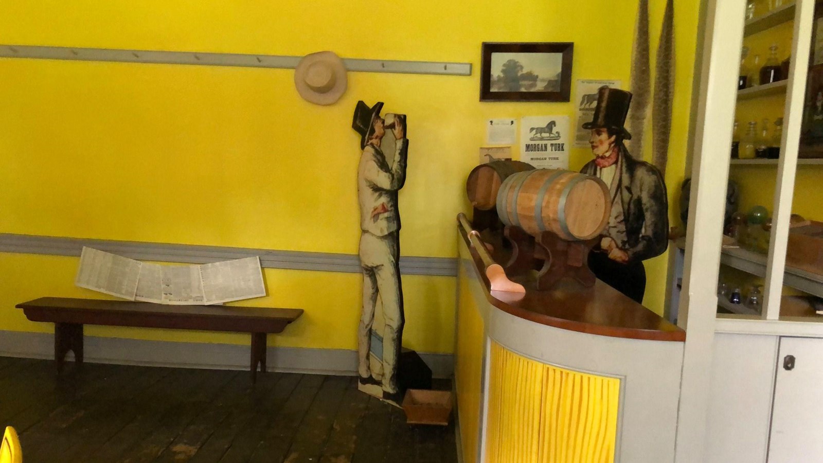 A brightly painted room with a bar and bottles on the shelves.