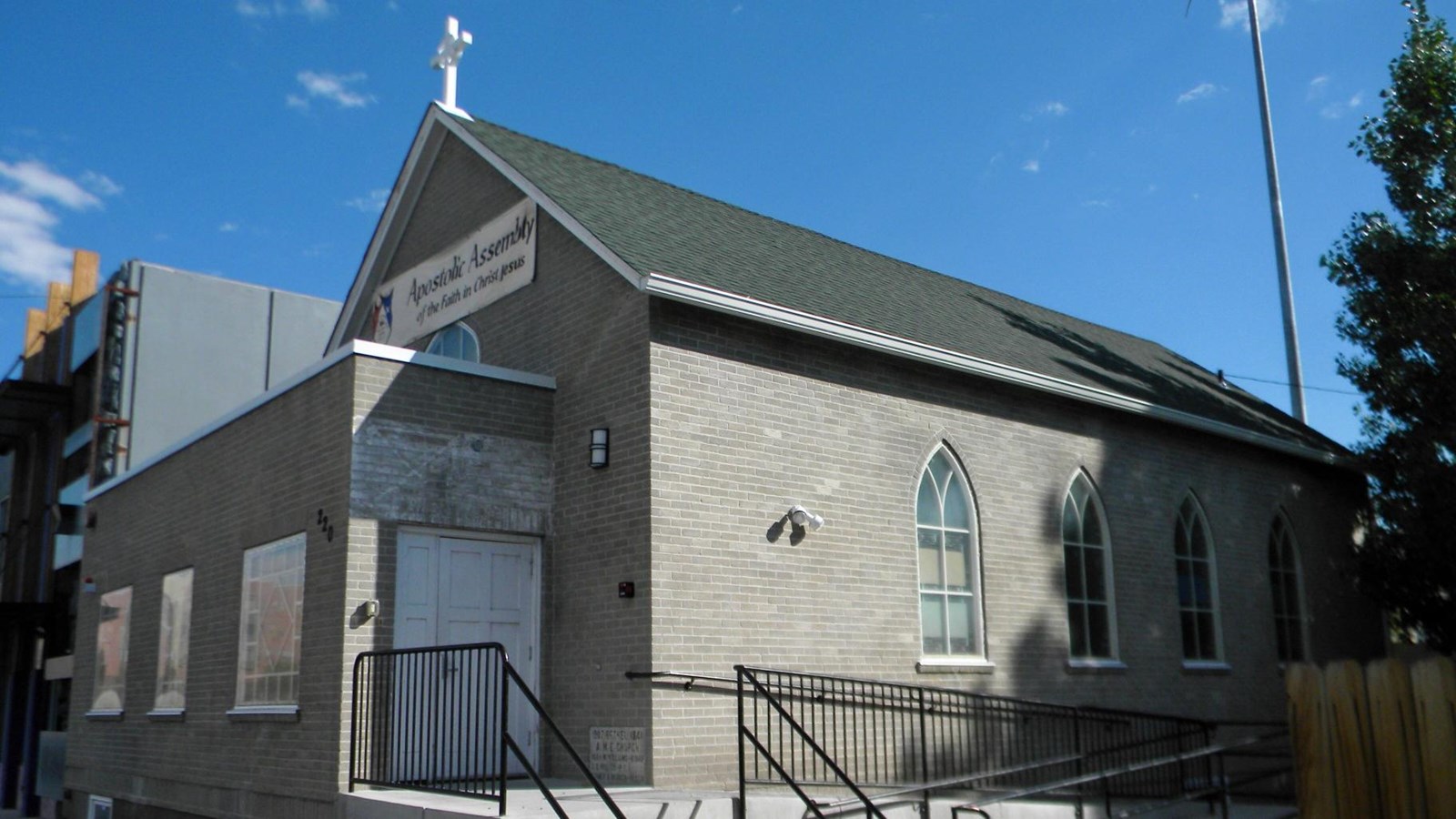 Photo of a gray church with stained glass windows.