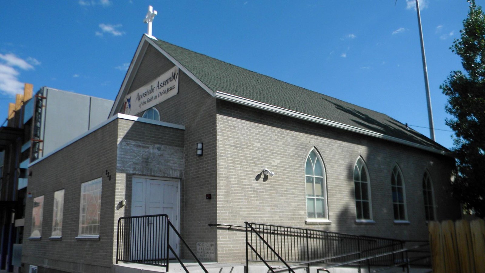 Photo of a gray church with stained glass windows. 