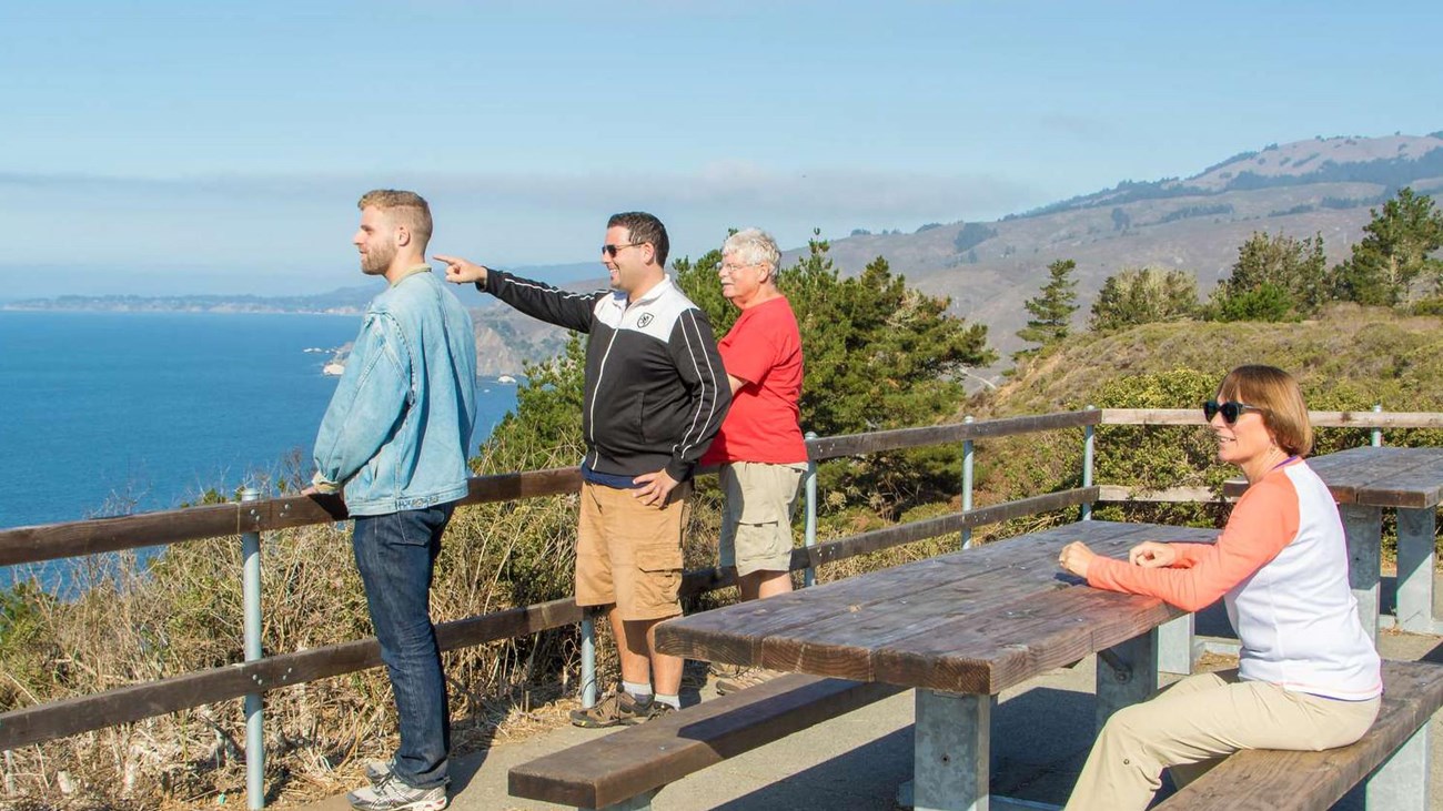 Visitors standing at the Muir Beach Overlook, looking out to sea, watching for whales