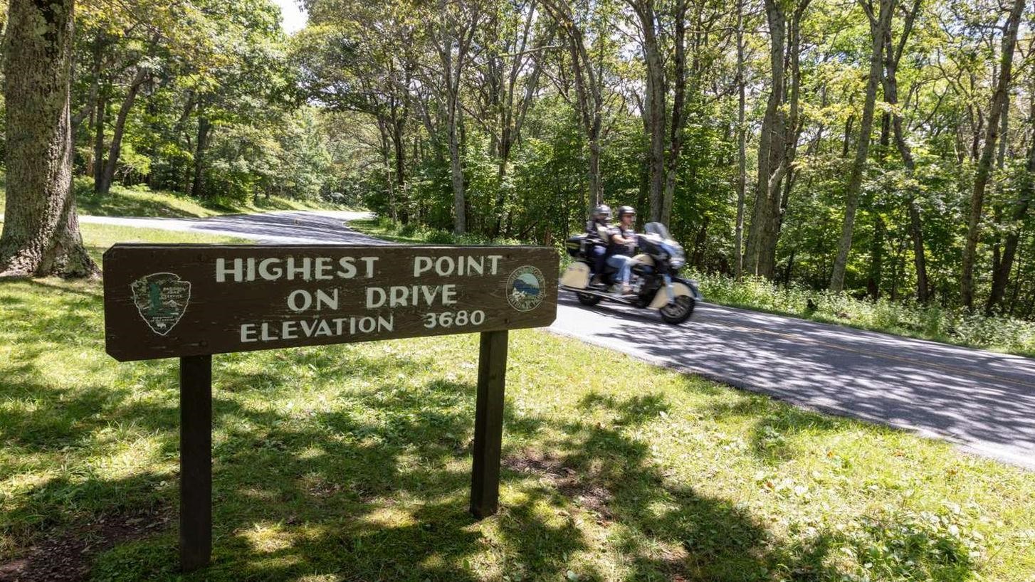 A wooden routed sign indicating the highest point on Skyland Drive at elevation 3680.