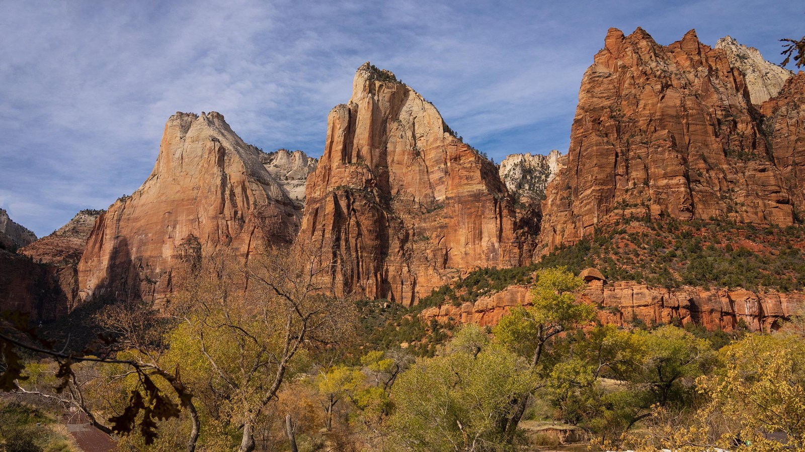 Photo of three large sandstone mountains above a shuttle bus.