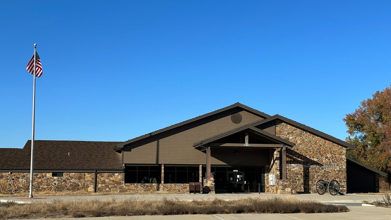 A large, brown stone building, with an awning over the front door.