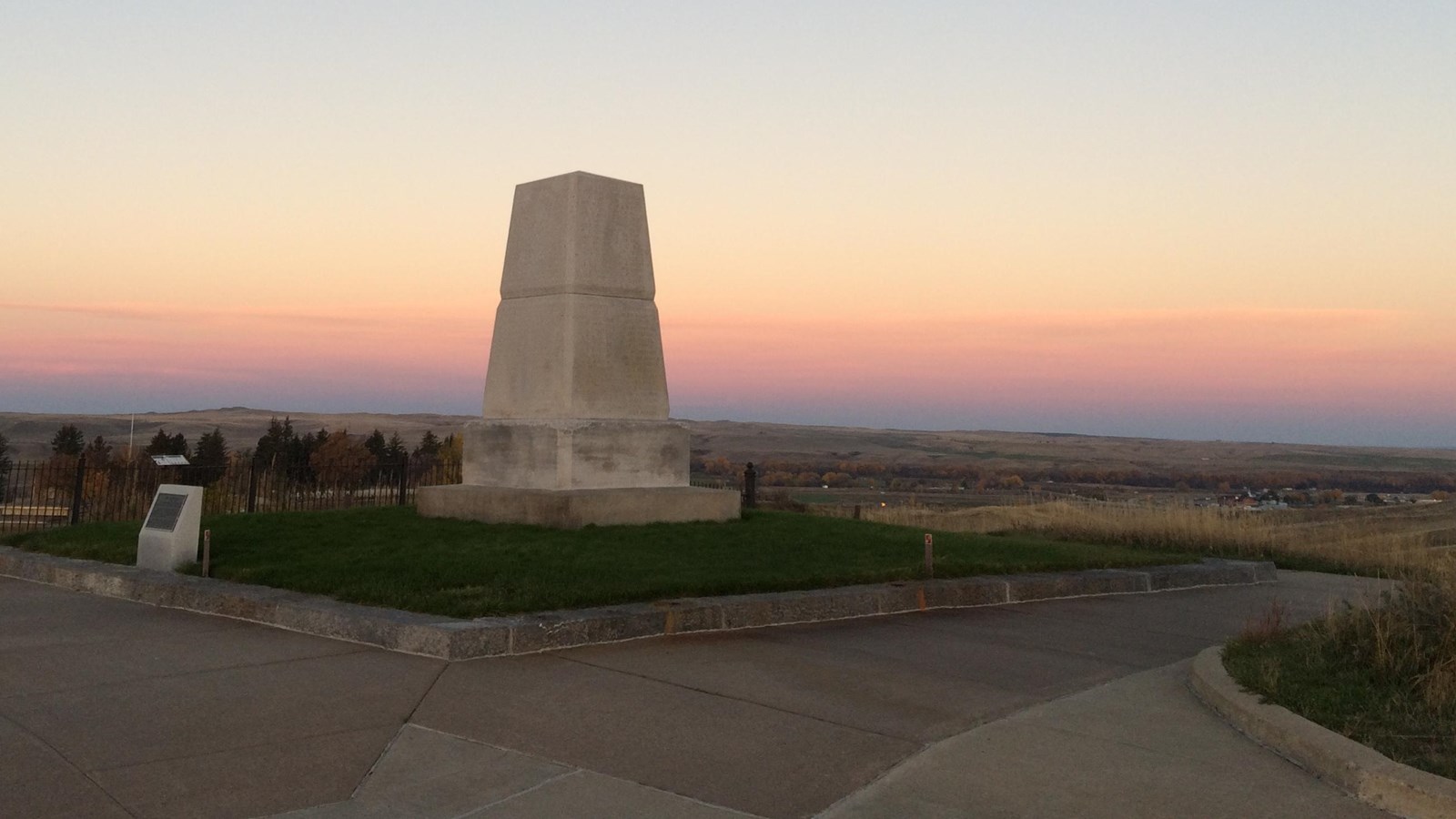 A blue and pink sunset behing a 15 foot stone monolith memorial. 