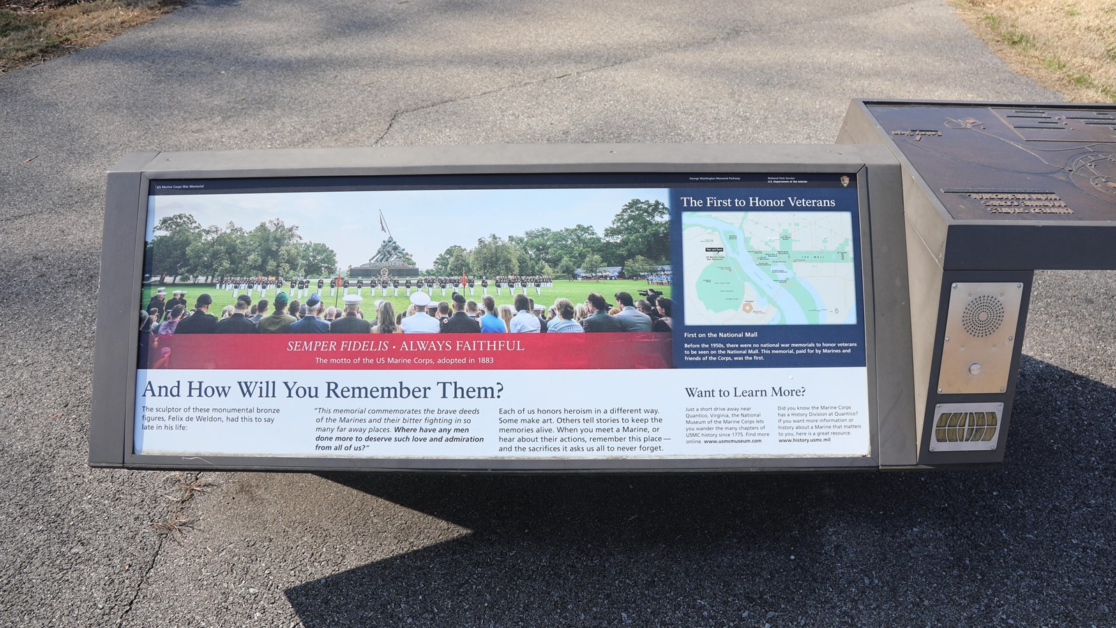 An information panel with text and photos with a bronze tactile map and a button below a speaker.
