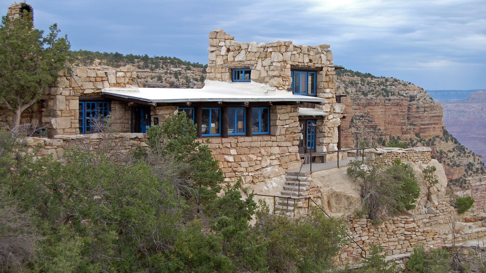 A multi-level white stone building perches right on the edge of Grand Canyon.