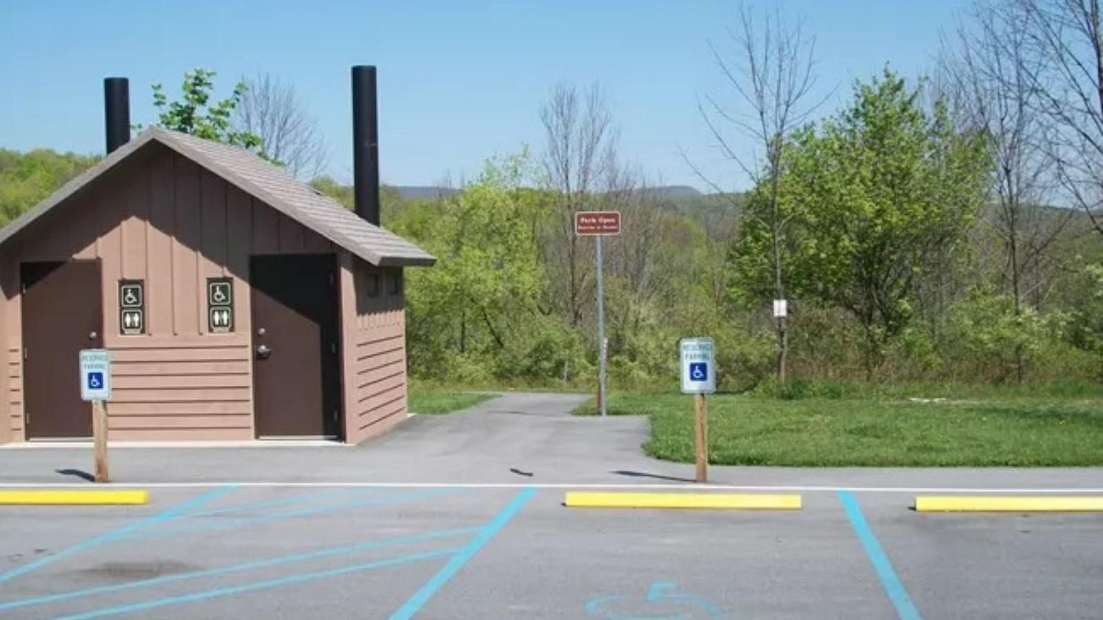 A parking lot with a brown structure that serves as a comfort station.