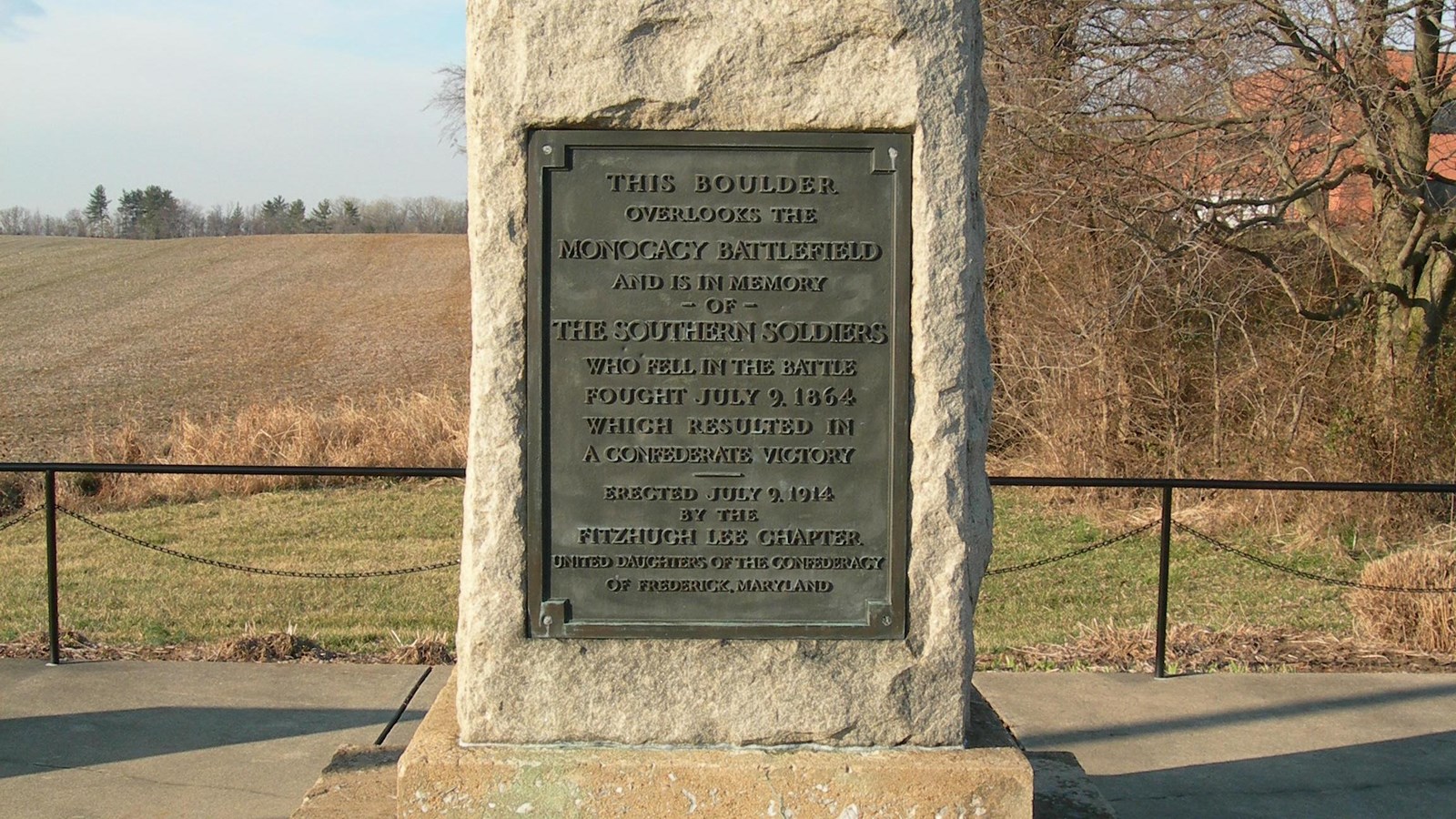 A tall, rough-cut granite block with a bronze plaque on the front.