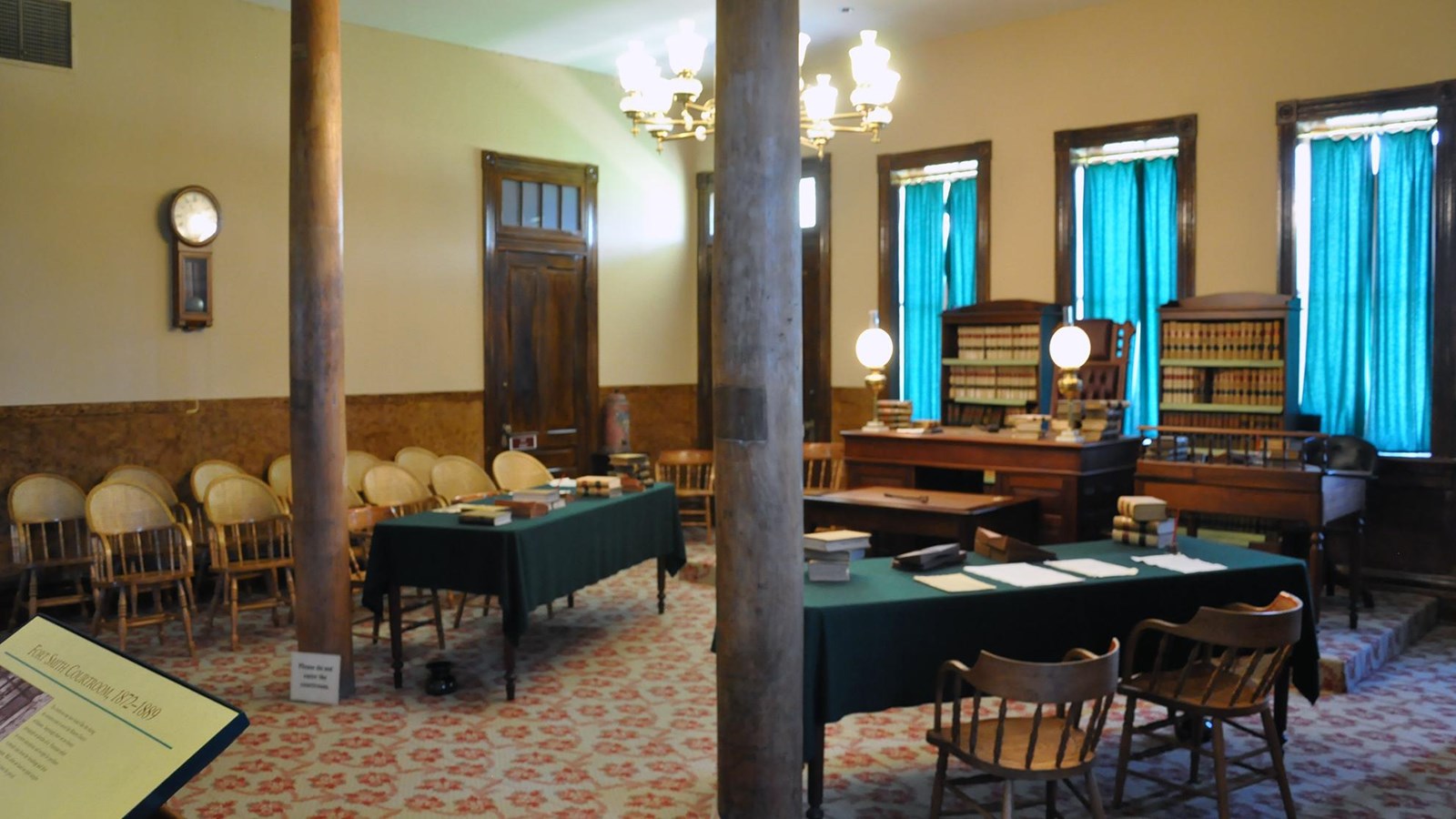 Courtroom – jury chairs on the left, two attorney tables in center and judge’s desk is center right.