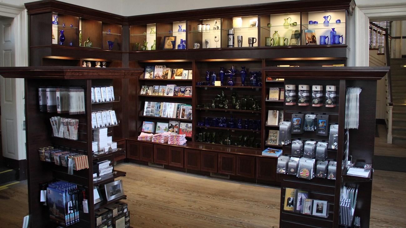 Interior view of a store featuring souvenirs on wall mounted and freestanding display cases.