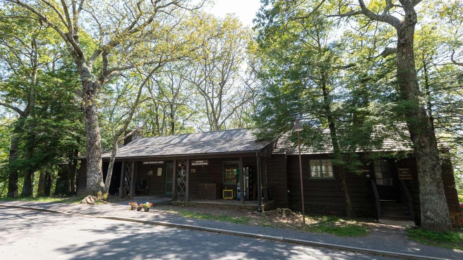 A brown, wood paneled building with a slanted roof and two entry ways.