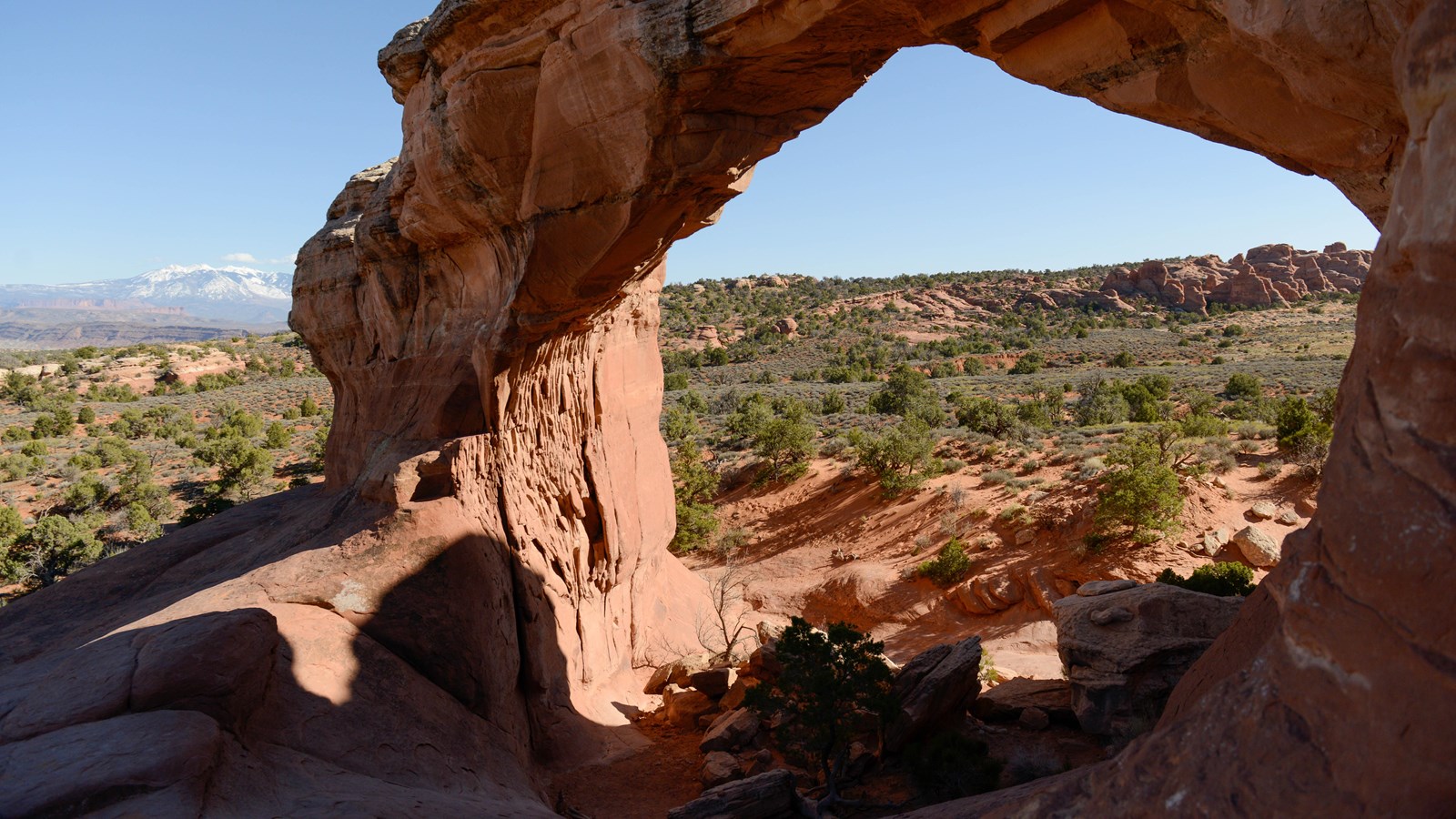 A stone arch frames a view of the landscape below