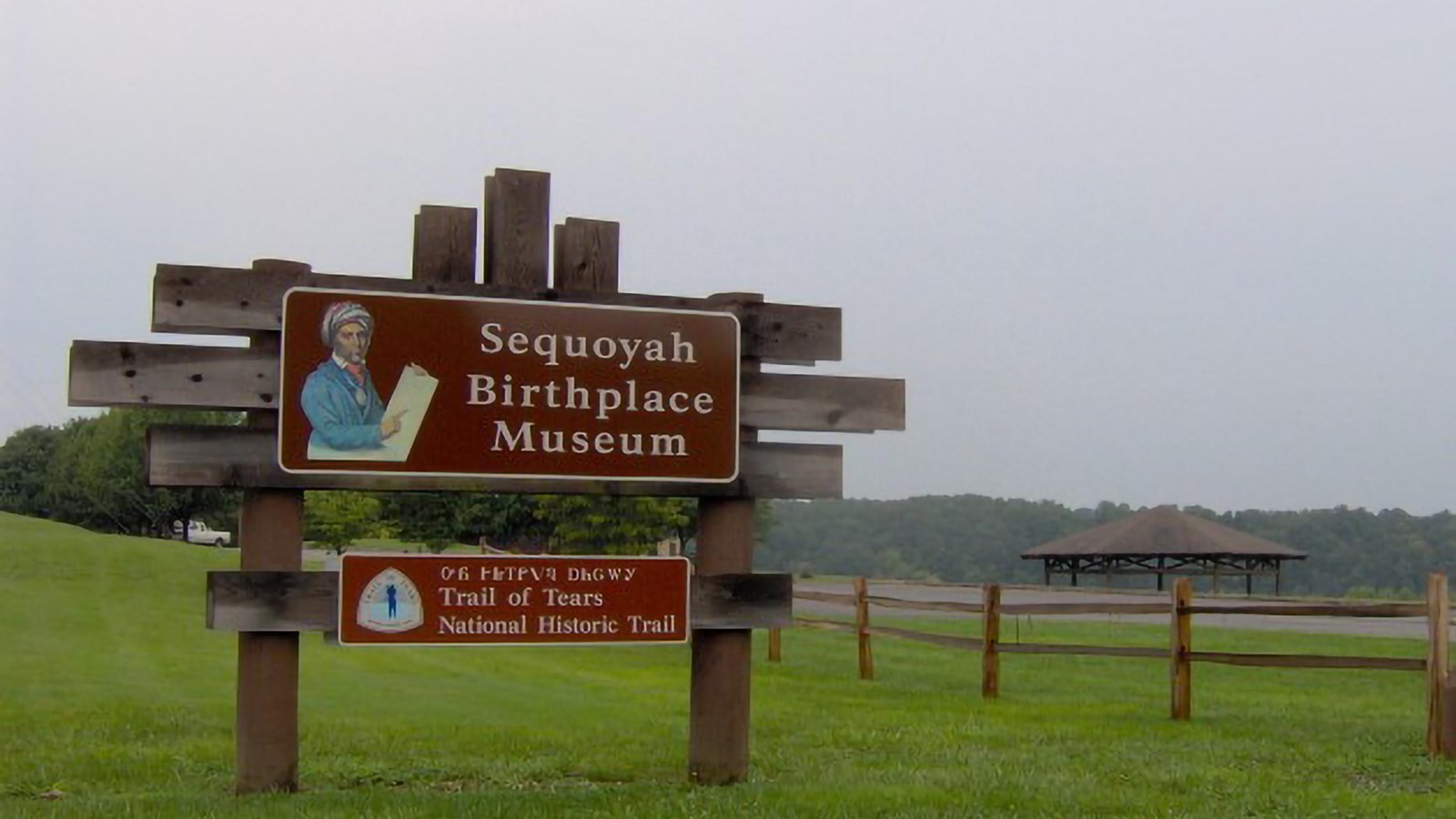 A brown sign with an image of Sequoyah reads Sequoyah Birthplace Museum, Trail of Tears NHT.